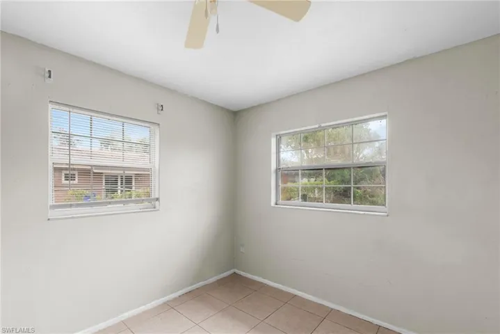 Spare room with light tile patterned flooring and a ceiling fan