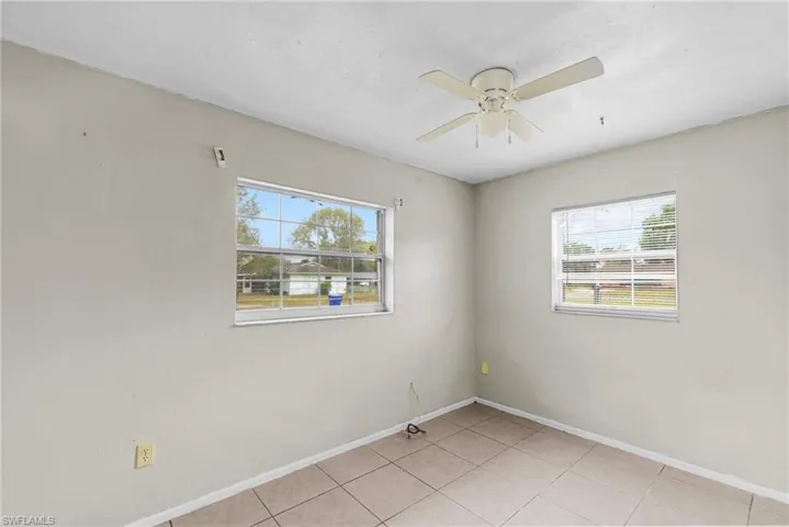 Spare room featuring plenty of natural light, light tile patterned floors, and a ceiling fan