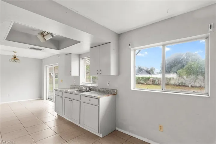 Kitchen featuring light countertops, white cabinets, and light tile patterned floors