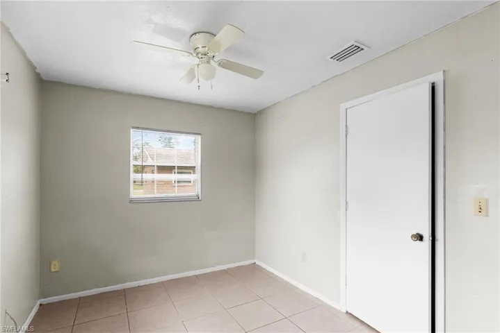 Empty room featuring ceiling fan and light tile patterned floors