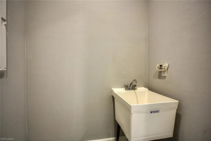 Utility room featuring a deep-basin thermoplastic sink and a dual-handle faucet