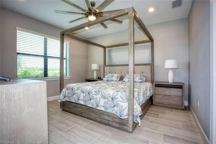 Room featuring large-format rectangular floor tile, recessed lighting, and a multi-blade ceiling fan with integrated light fixture