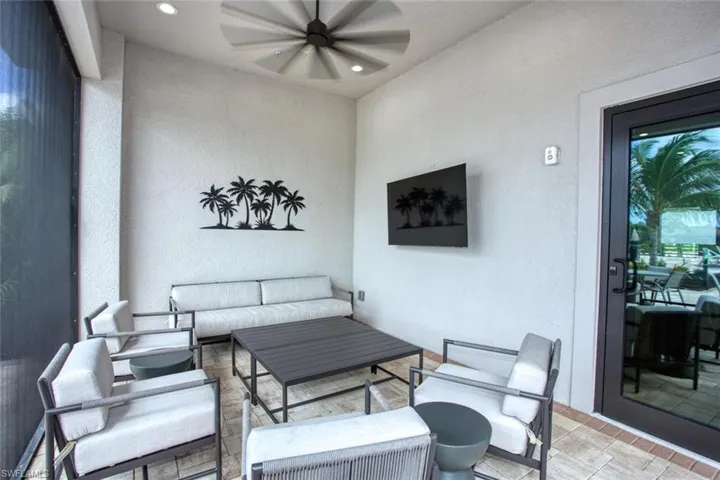 Covered patio featuring paver flooring, recessed ceiling lighting, a multi-blade ceiling fan, and a wall-mounted television