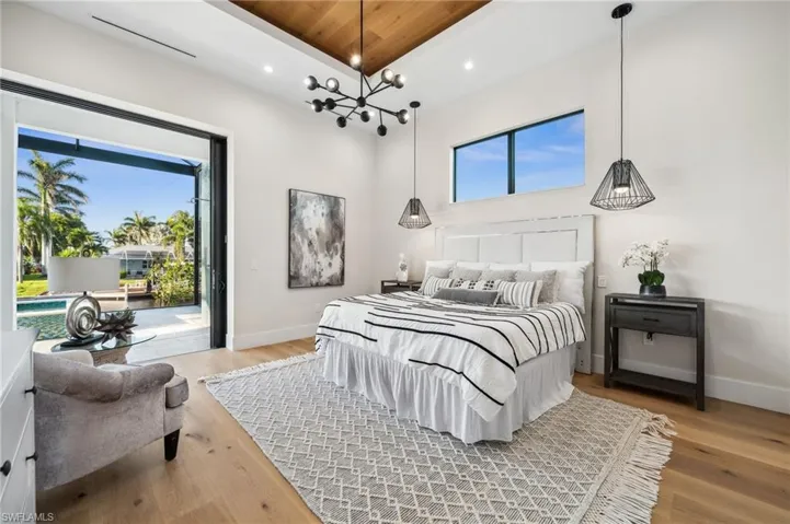 Bedroom with recessed lighting, multiple windows, light wood finished floors, and access to exterior
