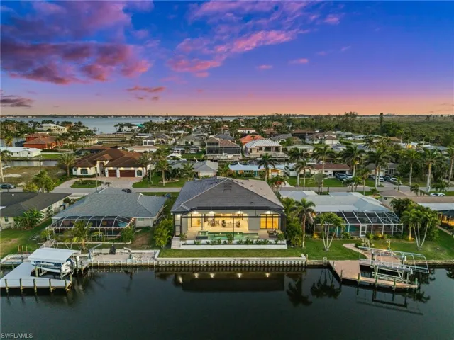 Aerial view at dusk featuring a residential view and a water view
