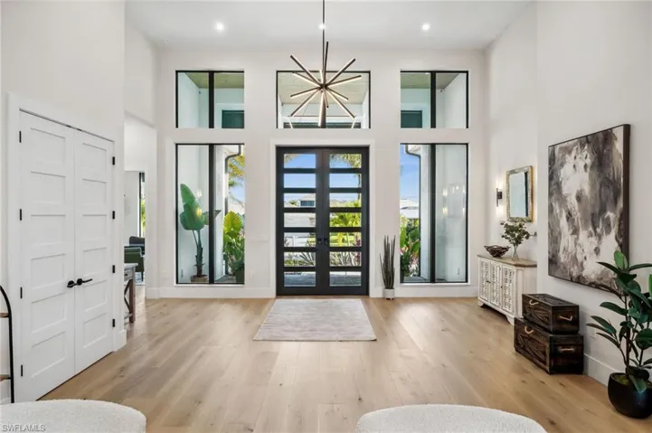 Entrance foyer featuring recessed lighting, french doors, a towering ceiling, and light wood-type flooring