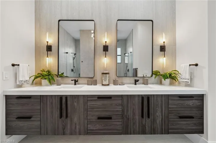 Bathroom with a sink, a shower stall, and double vanity