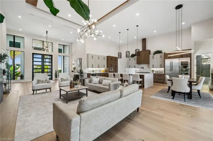 Living room with light wood-style flooring, a high ceiling, and a wealth of natural light