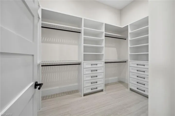 Spacious closet featuring light wood-style flooring