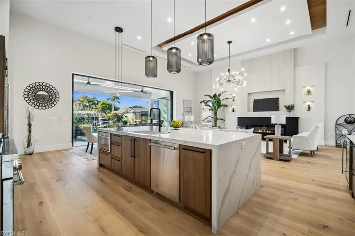 Kitchen featuring modern cabinets, stainless steel dishwasher, light wood-style flooring, and a spacious island