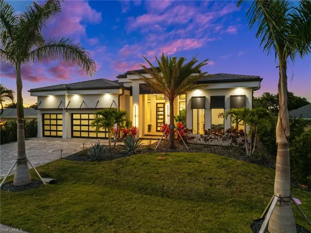 View of front of house with stucco siding, an attached garage, decorative driveway, and a lawn