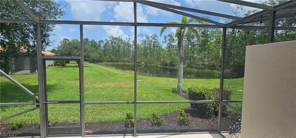 Unfurnished sunroom with view of wooded area, a water view, and healthy amount of natural light