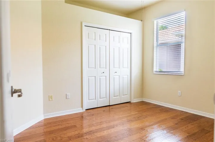Unfurnished bedroom with light wood-style floors, a closet, and baseboards