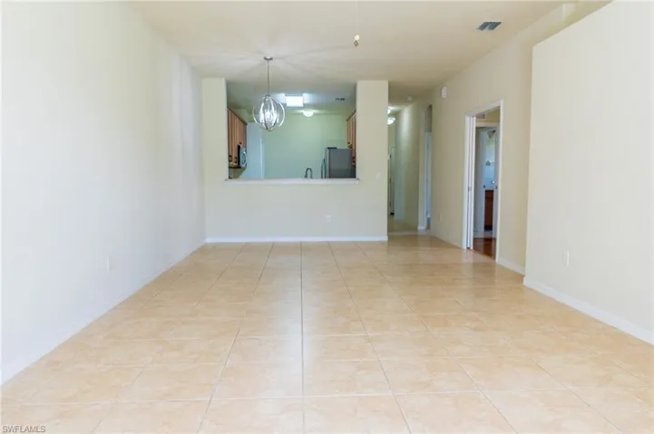 Spare room with light tile patterned flooring and a chandelier