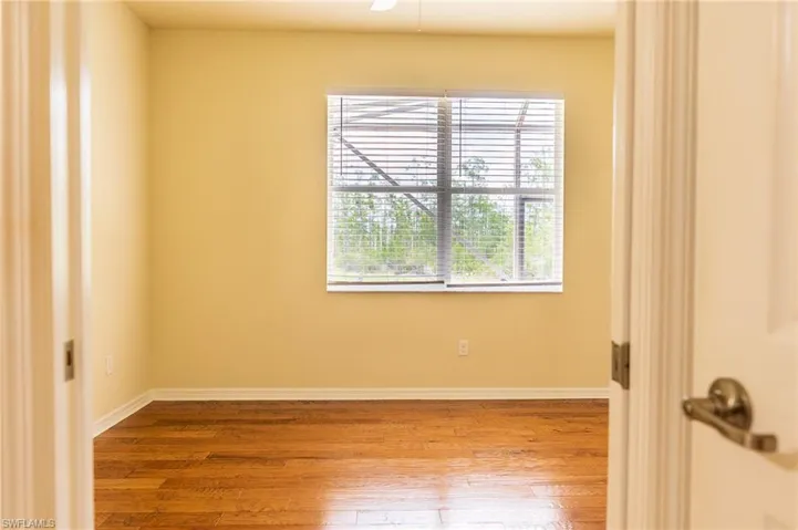 Unfurnished room with wood finished floors and baseboards