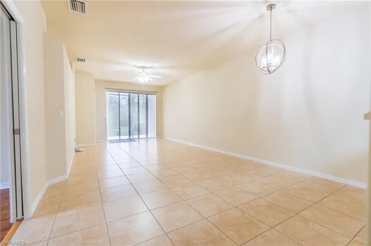 Empty room with light tile patterned flooring, a ceiling fan, and baseboards