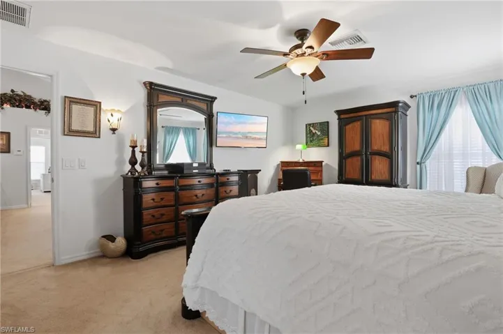 Bedroom with light colored carpet and a ceiling fan
