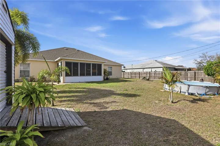 Fenced backyard featuring a sunroom