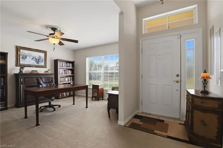 Foyer entrance featuring ceiling fan and light colored carpet