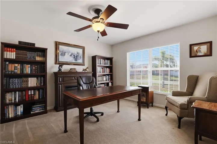 Office with light colored carpet and a ceiling fan