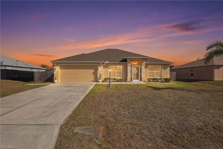 View of front facade featuring stucco siding, a garage, concrete driveway, and a shingled roof