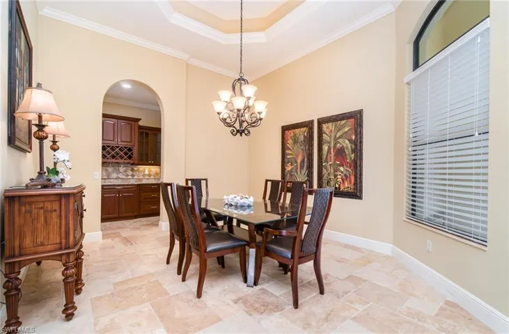 Dining space featuring a tray ceiling, ornamental molding, and a chandelier