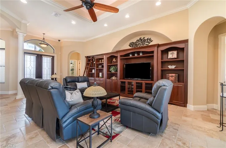 Living room featuring crown molding, ceiling fan