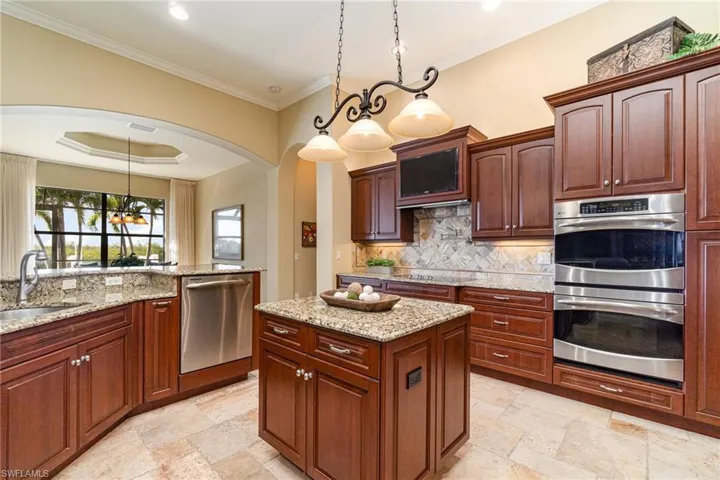 Kitchen featuring pendant lighting, sink, decorative backsplash, and appliances with stainless steel finishes