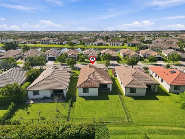 Expansive green lawn with a fenced rear yard, tile roof, and a paved patio area