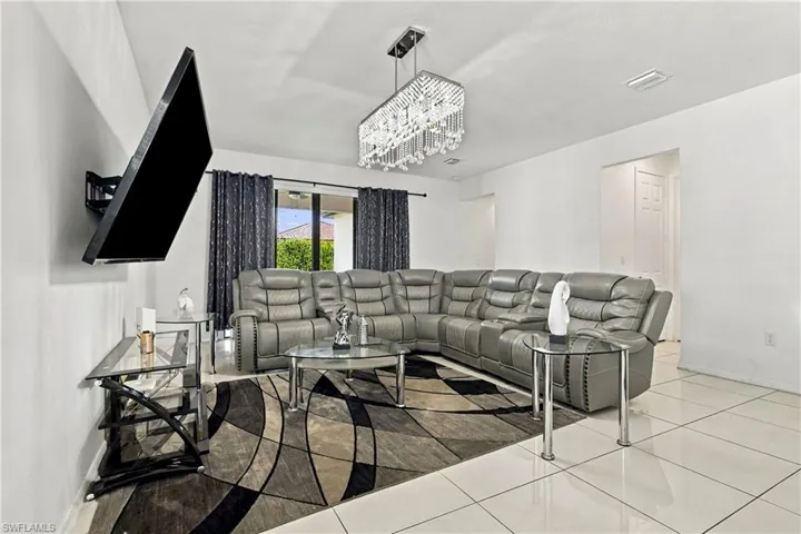 Recessed lighting and a multi-tiered crystal chandelier illuminate the space