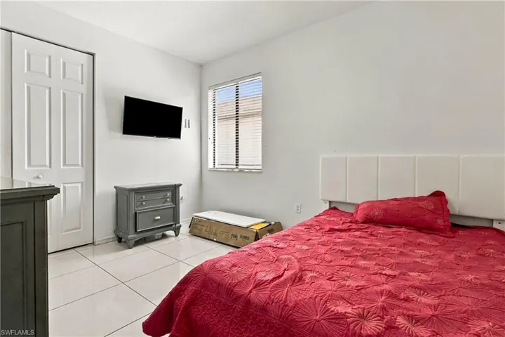 White wall finish, tile flooring, and a single window with blinds