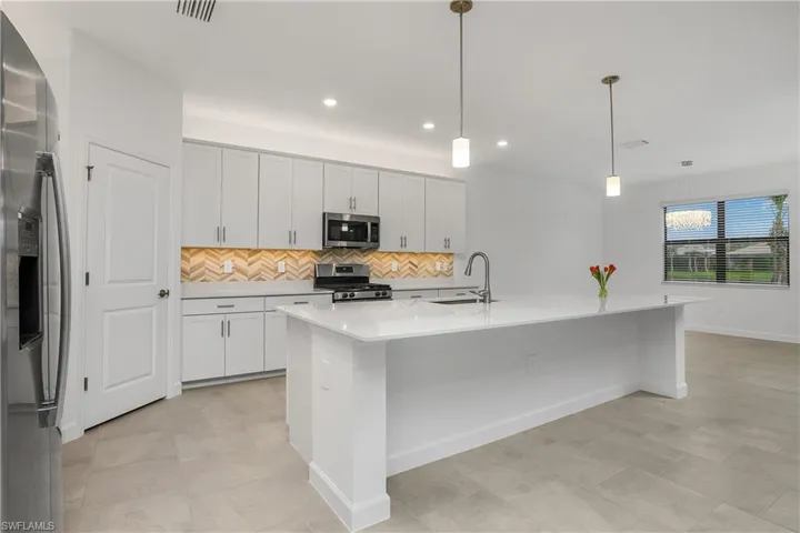 Spacious kitchen is a chef's dream featuring natural gas stove/cooktop, oversized island, walk-in pantry, and family dining space.
