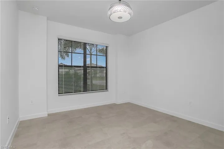 Spacious guest bedroom at the front of the home includes chandelier/ceiling fan and plenty of natural light.