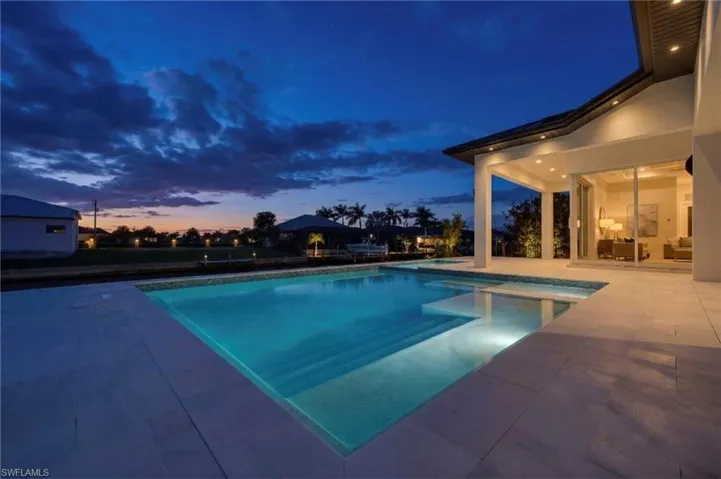 Pool at dusk with a patio and an outdoor pool