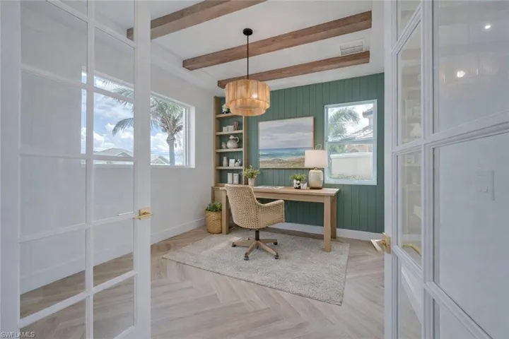 Office area featuring parquet flooring, beam ceiling, and wood walls