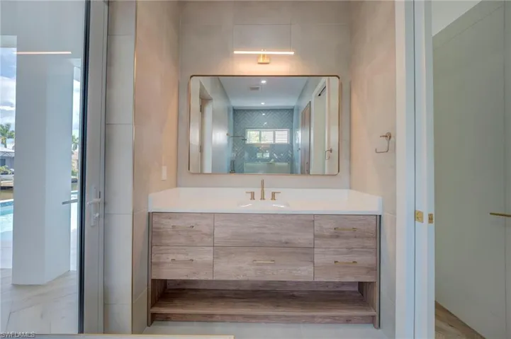 Bathroom featuring vanity, a stall shower, and tile walls