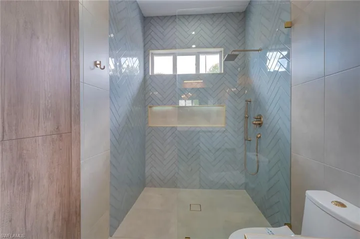 Bathroom featuring walk in shower and tile walls