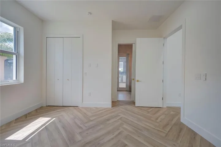 Unfurnished bedroom featuring a closet and parquet floors