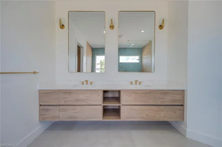 Bathroom with double vanity and baseboards