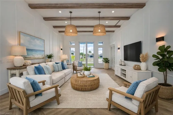 Living area featuring a decorative wall, light wood-style floors, a high ceiling, and recessed lighting