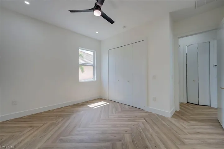 Unfurnished bedroom featuring parquet floors, recessed lighting, a closet, and ceiling fan