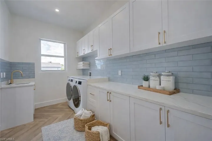 Laundry area featuring parquet floors, washing machine and dryer, cabinet space, and recessed lighting