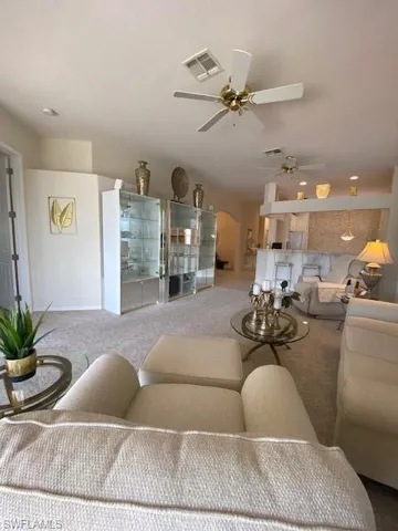 Living room featuring ceiling fan and carpet floors