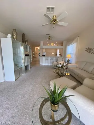 Living room with ceiling fan and carpet