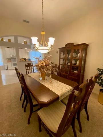 Dining room featuring light carpet and a chandelier