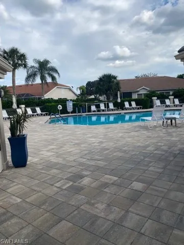 View of community swimming pool featuring a patio area