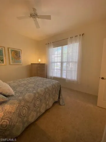 Carpeted bedroom featuring ceiling fan