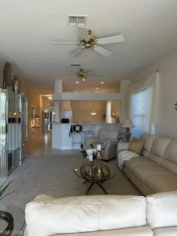 Tiled living room featuring ceiling fan