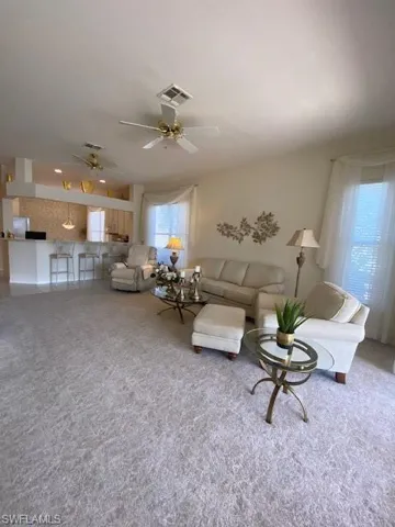 Living room with carpet flooring and ceiling fan