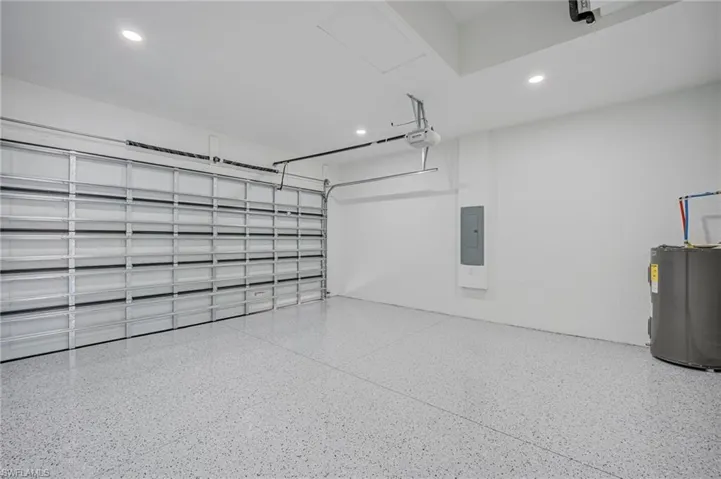Garage featuring electric water heater, recessed lighting, and electric panel